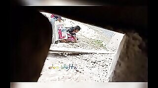 Eine reife indische Frau pinkelt in einem Softcore-Video auf einem Feld in Nahaufnahme.